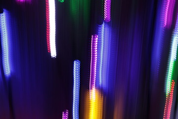 Una toma de cerca de varias luces de colores en movimiento en la oscuridad. Movimiento de cámara