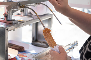 Woman stuffing churros covered with sugar and cinnamon with dulce de leche_1.