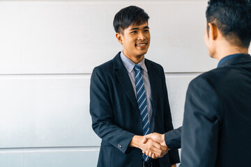 Business people agreement concept. Asian Businessman do handshake with another businessman in the office meeting room. uds