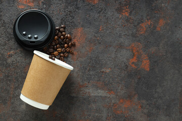 A craft cup for coffee with coffee beans on a dark background
