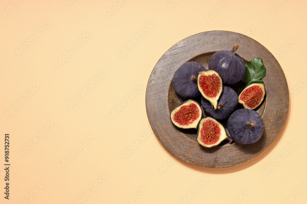 Sticker Fresh ripe figs in a wooden bowl on a light background