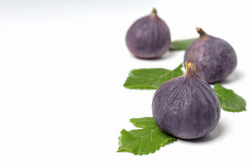 Fresh ripe figs with leaves on a white background
