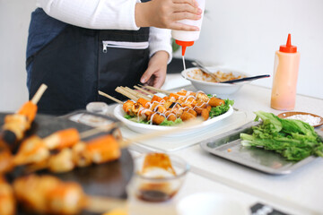 Woman Making Satay From Dumplings at The Kitchen