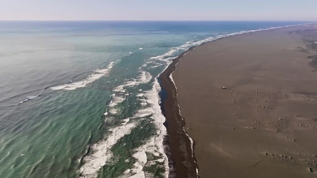 Endless brown sand beach and ocean in Iceland, aerial dolly in, empty landscape
