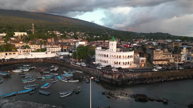 Aerial view showcasing Port Badjanan with empty fishing boats and the Badjanani Mosque in the background in Moroni, Comoros. Dolly Shot