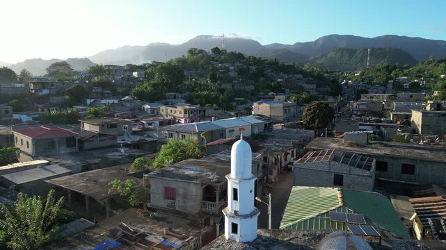 Aerial close up of white stone old Muslim mosque in Moh&eacute;li or Mwali, part of the Union of the Comoros, drone fly above small beach town during warm afternoon light