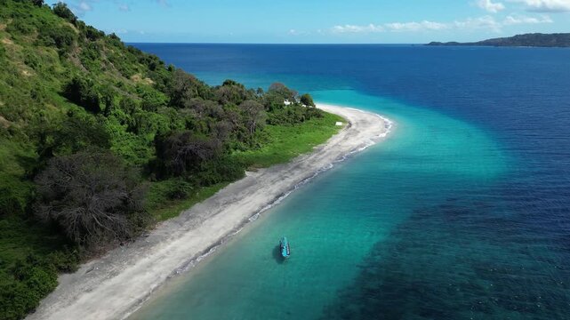 aerial of lonely boat on remote tropical islet white sand beach in Moh&eacute;li or Mwali, part of the Union of the Comoros, Africa&rsquo;s east coast, blue Indian Ocean waters