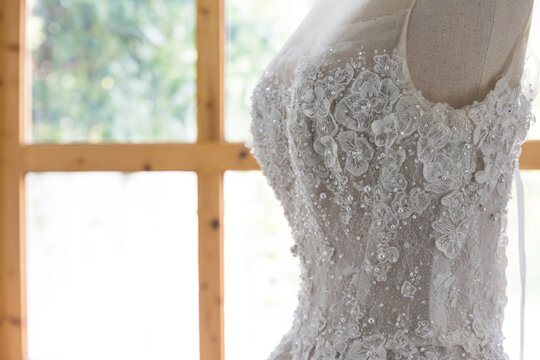 White wedding dress on a mannequin doll in studio.A wedding dress or bridal gown is the dress worn by the bride during a wedding ceremony.