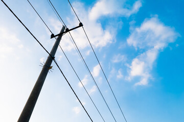 An electric pole with a cable connected under the sky