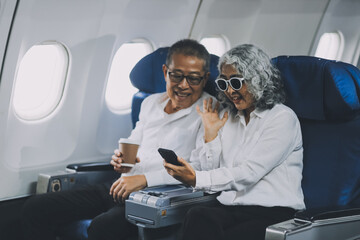Happy elderly senior couple of travelers with suitcase in airport