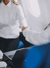 Professional pilot woman in uniform has teamwork meeting for success flight in aviation business. Young female captain instructor sitting in office and working or training commercial airline crew.