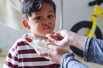 A child being fed by his mother