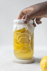 lemon cheong in a glass jar on a white background, korean lemon cheong in a transparent jar, lemon slices in sugar syrup
