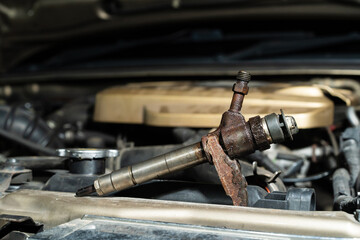 Repair fuel injection.Common rail diesel injection system on track..Under the hood of an old car is an old rusty engine.