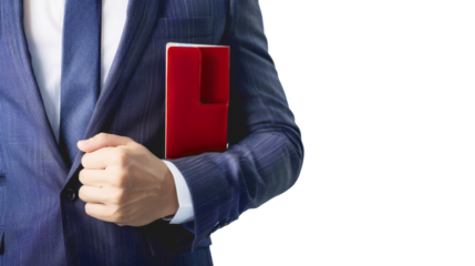 Close-up of a man in a blue suit holding a red notebook while adjusting his jacket