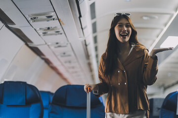 Asian woman walking with luggage in airplane cabin. Concept of travel, transportation, and journey