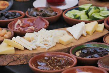 An Assorted Selection of Cheese and Delectable Delicacies Presented on a Wooden Board