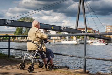 Old Granpa sitting on Spree Banks, An older man sits on his walker on the banks of the Spree and...