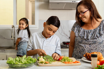 Grandmother helping to her grandchild to cutting lettuce.