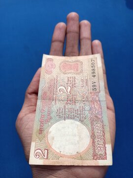 Indian two rupees note in hand on isolated background