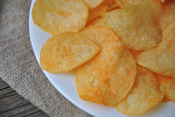 Delicious potato chips on a white plate close-up. selective focus