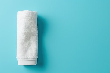 Obraz premium White towel on blue background with antiperspirant deodorant Concept for skin care Top view with copy space
