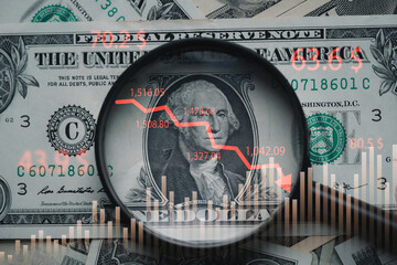 Red down arrow inside of magnifier glass and USD dollar banknote for United States of America or...