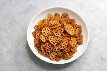 Crispy lotus stem chips, perfectly spiced and golden-brown, offer a delightful crunch and unique flavor. Ideal for snacking or as a gourmet appetizer. kurkuri Kamal kakdi. copy space.