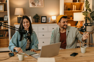 Two people in the podcast studio talking and recording during the day