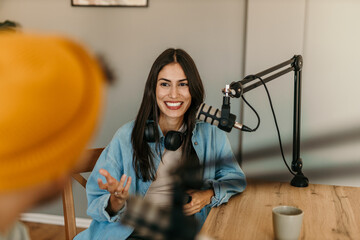 A man and woman working on the radio station, having a talk show. Focus on a woman