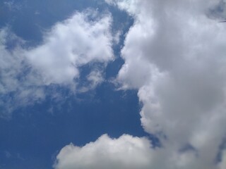 Sun shining through the puffy clouds. Sky view. Beautiful sunny sky. Background with clouds on blue sky. Clouds on blue sky.
