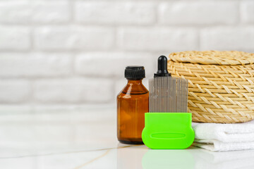 Bottles of Lice Treatment Products and a Comb on a Countertop