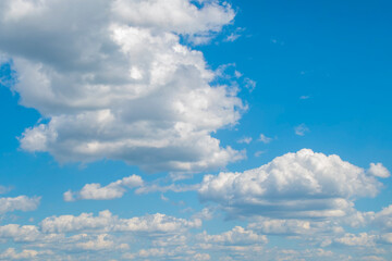 Background with cumulus clouds in summer. Panorama with light blue sky with white clouds.