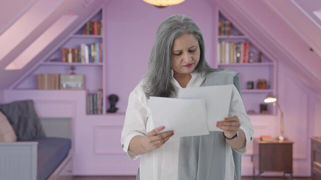 Old indian woman reading reports