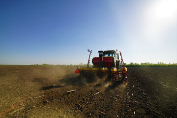 Fototapeta premium Agricultural land is cultivated by a tractor, sowing seeds.