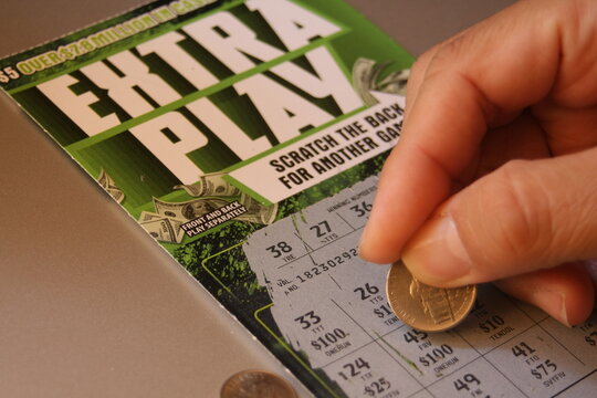 WASHINGTON, USA - August 08, 2024 - Man's hand scratching off lottery ticket in America, scratch-off lottery, lucky, take a chance