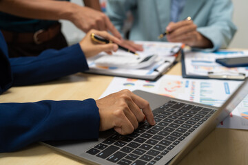 A businessperson, holding hands, cooperate during a corporate meeting.  review a graph document together, discussing strategies and financial data to achieve successful outcomes and effective