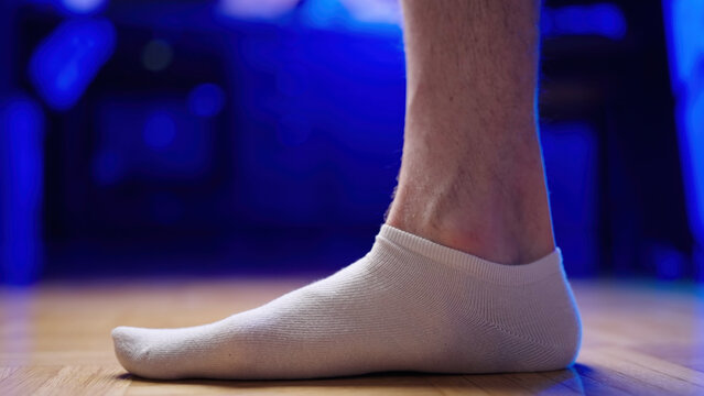 Flat foot with relaxed arch side view wearing white socks close-up