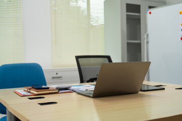 An executive work desk sits in an office, meticulously arranged with documents and office supplies. The space is empty, awaiting the return of the executive to resume daily business activities.