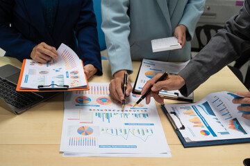 A businessperson, holding hands, cooperate during a corporate meeting.  review a graph document together, discussing strategies and financial data to achieve successful outcomes and effective