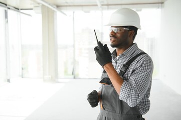 african male builder talking on his radio