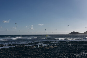 Men professional surfer standing on the sandy beach with his kite and board. Windsurfing, Extreme...