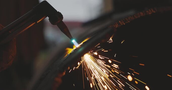 Worker in protective gear using oxy-fuel torch