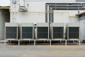 Air compressor or air condenser unit located on support outside building to heat released...