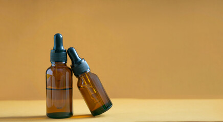 Serum in glass amber bottle with dropper lid. Essential oil for care of women's skin on brown...