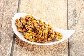 Cracked unshelled walnut in the bowl