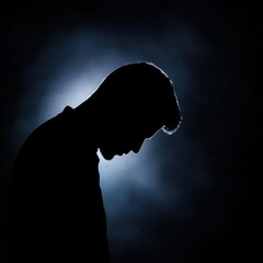 Naklejka premium A solitary figure in silhouette against a soft, illuminated background, embodying contemplation and introspection.