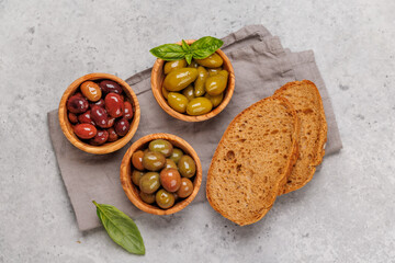 An assortment of various olives presented in a bowl, showcasing different colors, textures, and flavors