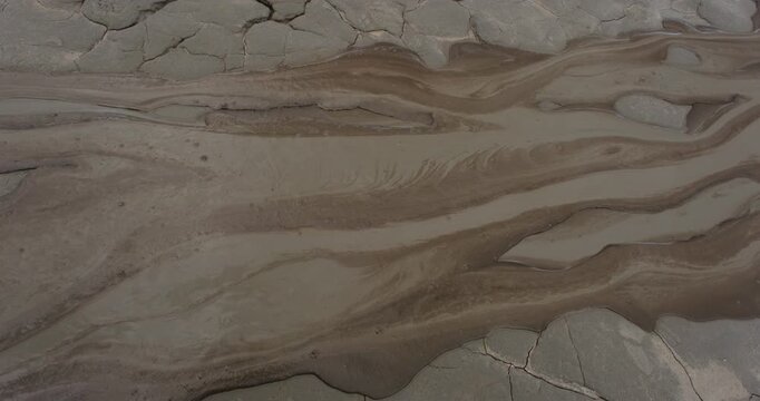 Muddy Vulcanos located in Buzau County, Romania, a National Landmark, Gas bubbles coming out a mud volcano. Paclele mici and Paclele Mari