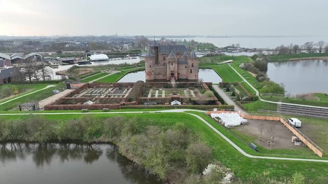 Drone footage of Fort Muiderslot in the Netherlands highlights its impressive medieval structure, surrounded by moats and lush gardens, offering captivating aerial views of this historic fortress